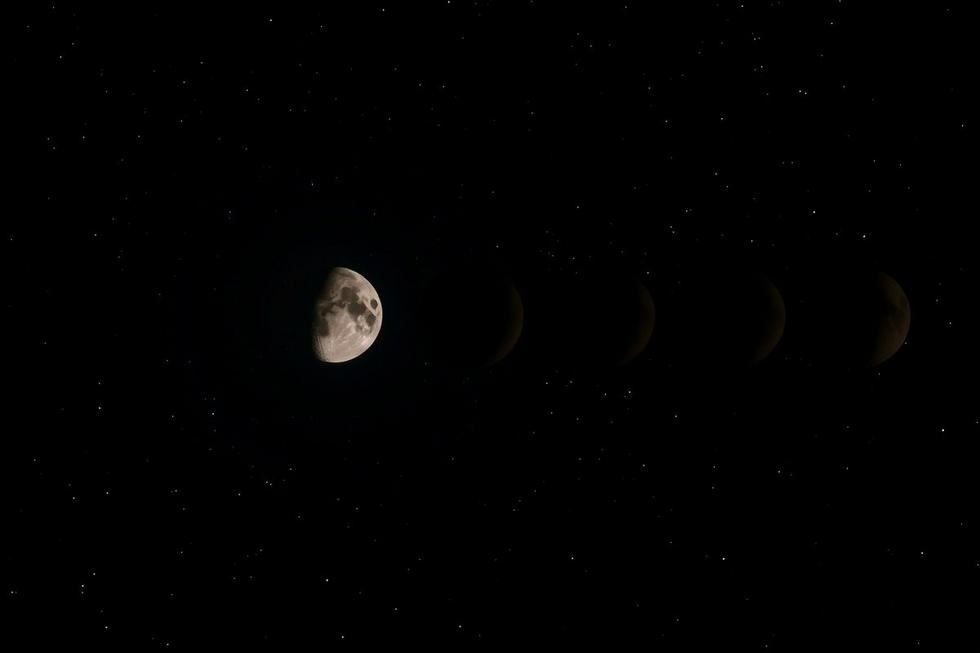 Vista da lua em diferentes fases em um céu nocturno estrelado.