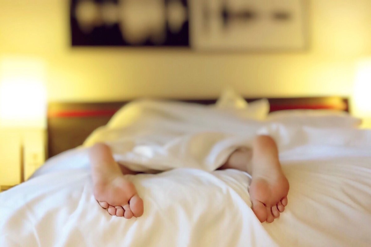 Como melhorar a qualidade do sono — cama arrumada e ambiente escuro